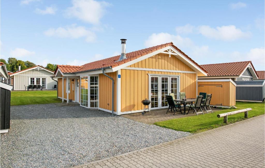 uma casa amarela com uma mesa e cadeiras em Marina Fiskens Feriepark em Egernsund