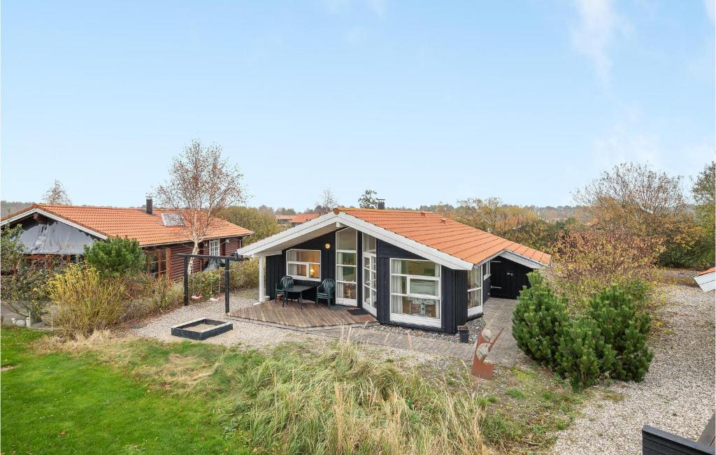 een klein huis met een dak op een erf bij Cozy Home In Vggerlse With Kitchen in Bøtø By