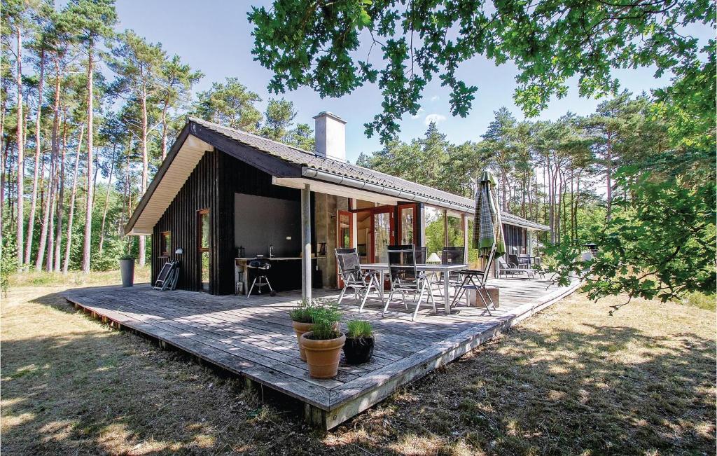 Vester Sømarkenにある3 Bedroom Stunning Home In Aakirkebyの小さなキャビンで、デッキ(テーブル、椅子付)が備わります。