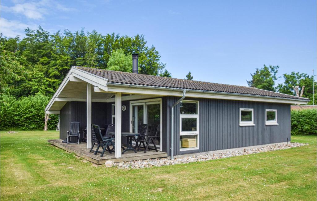 una casa pequeña con porche y terraza en Stunning Home In Rudkbing With 3 Bedrooms, Sauna And Wifi, en Spodsbjerg