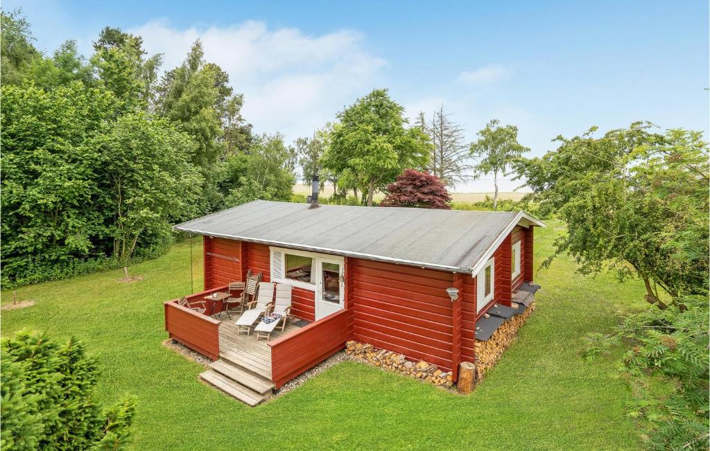 a red tiny house with a deck in a field at Cozy Home In Mern With Wifi in Mern