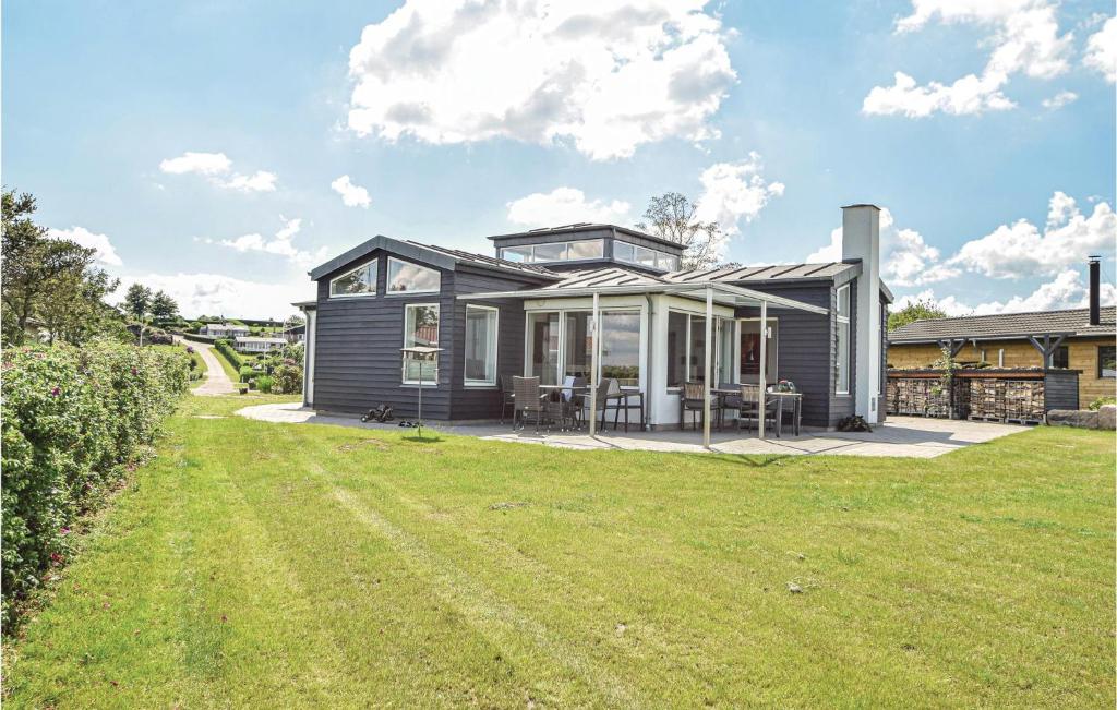 a black house with a lawn in front of it at 4 Bedroom Lovely Home In Brkop in Hvidbjerg