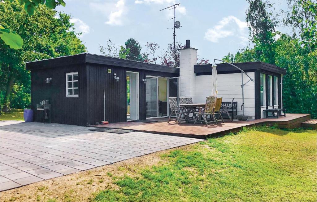 a small black and white shed with a patio at Awesome Home In lsted With 3 Bedrooms And Wifi in Ølsted