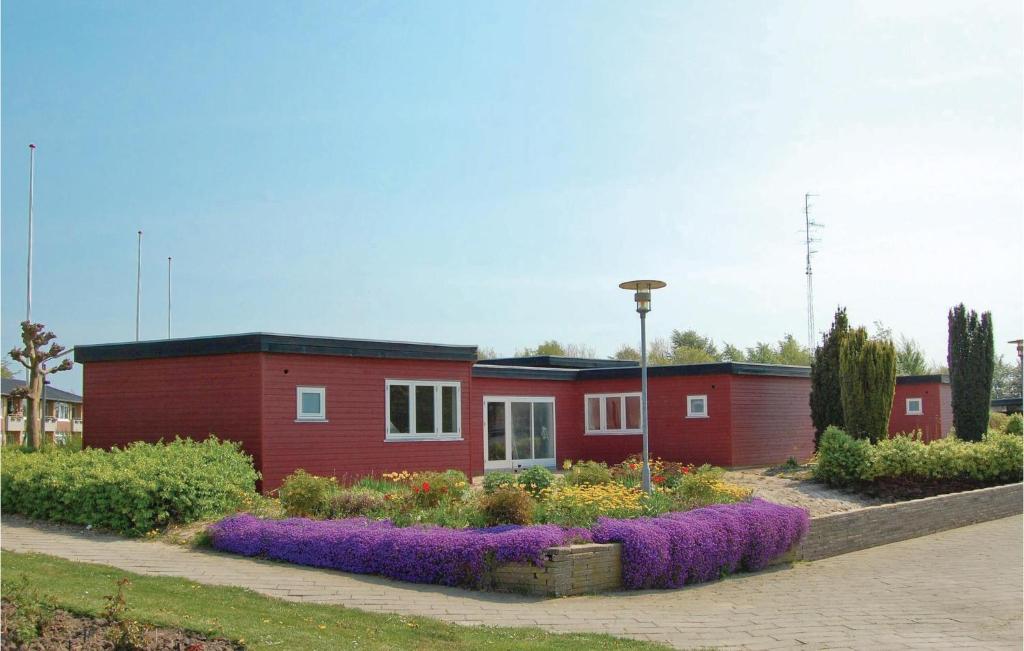 une maison rouge avec des fleurs devant elle dans l'établissement Lovely Home In Nordborg With Wifi, à Nordborg