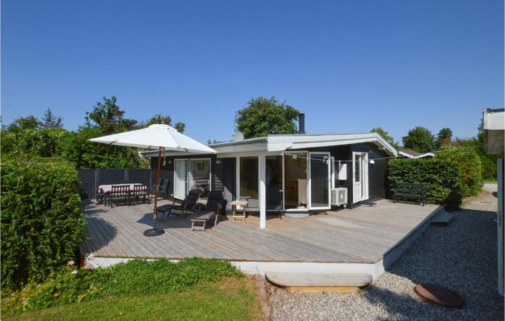ein Haus mit einer Holzterrasse mit einem Sonnenschirm in der Unterkunft Beautiful Home In Slagelse With Kitchen in Slagelse