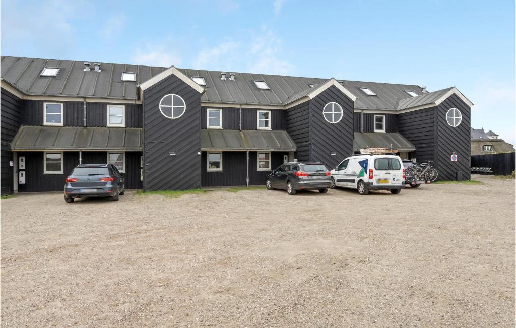 ein großes schwarzes Haus mit Autos auf einem Parkplatz in der Unterkunft Lejl, 302, 1, Sal in Fanø