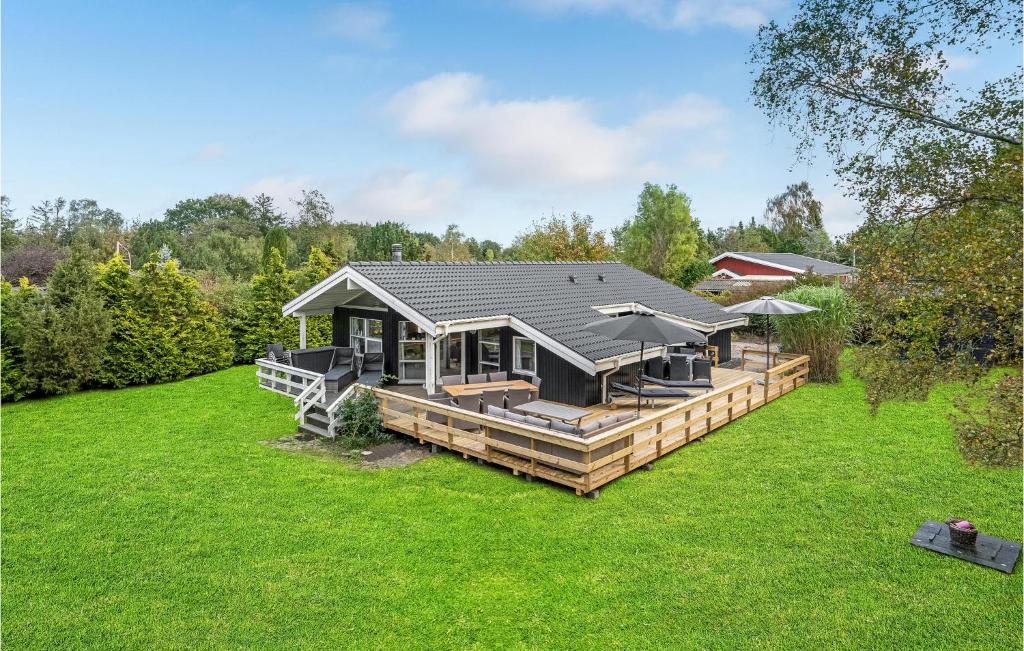 een huis met een groot terras in een tuin bij Amazing Home In Grenaa With Sauna in Stokkebro