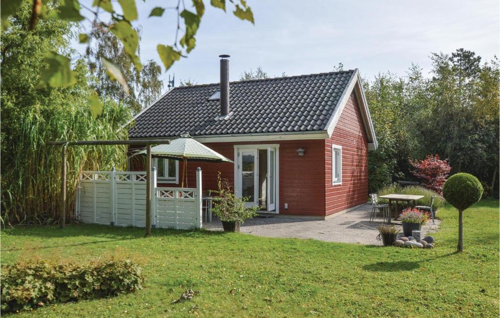 una pequeña casa roja con una mesa de picnic en un patio en Beautiful Home In Kalundborg With Kitchen, en Kalundborg