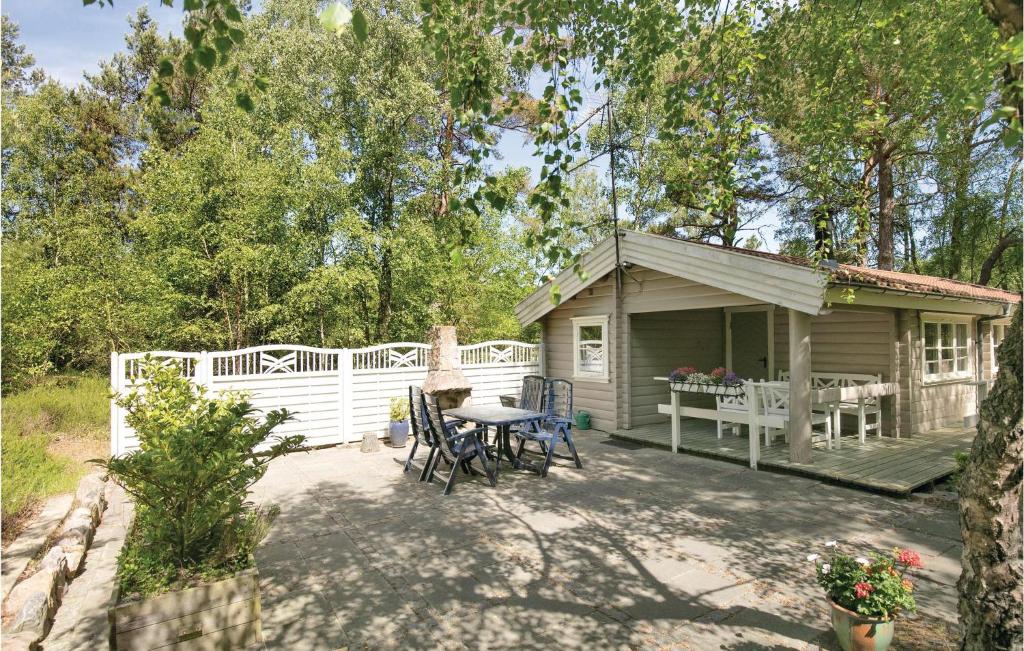 Cabaña pequeña con patio con mesa y sillas en Gorgeous Home In Nex With Wifi en Bedegård