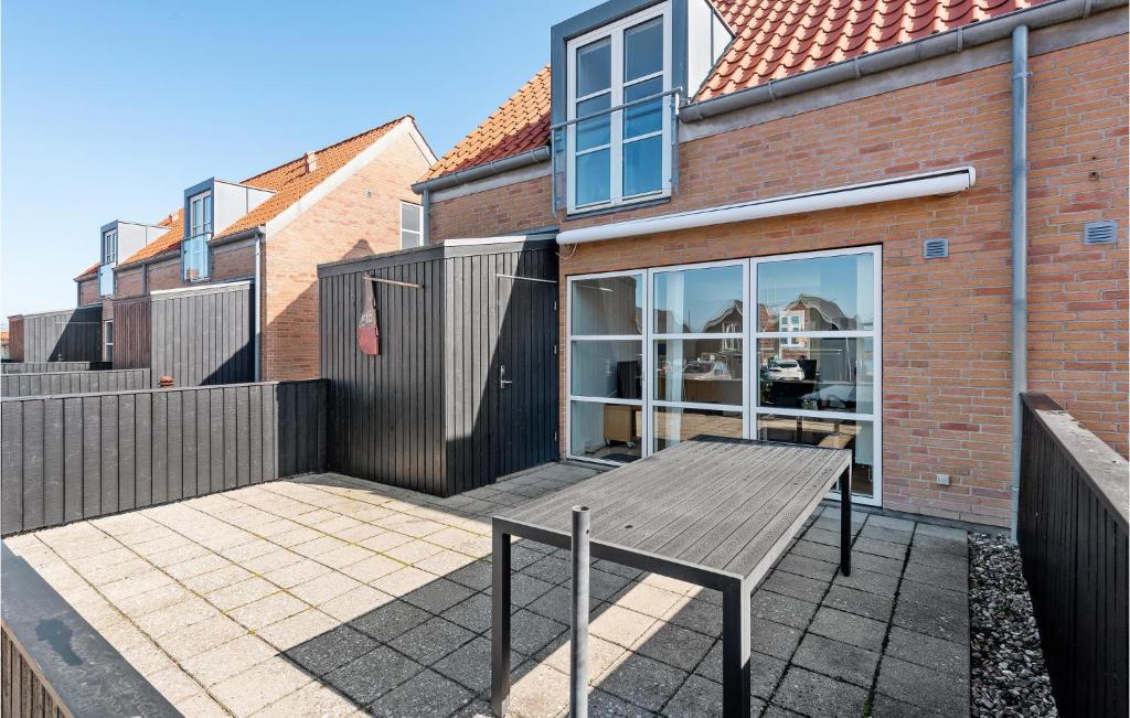 un patio con tavolo in legno di fronte a una casa di Gorgeous Home In Tranekær With Kitchen a Tranekær