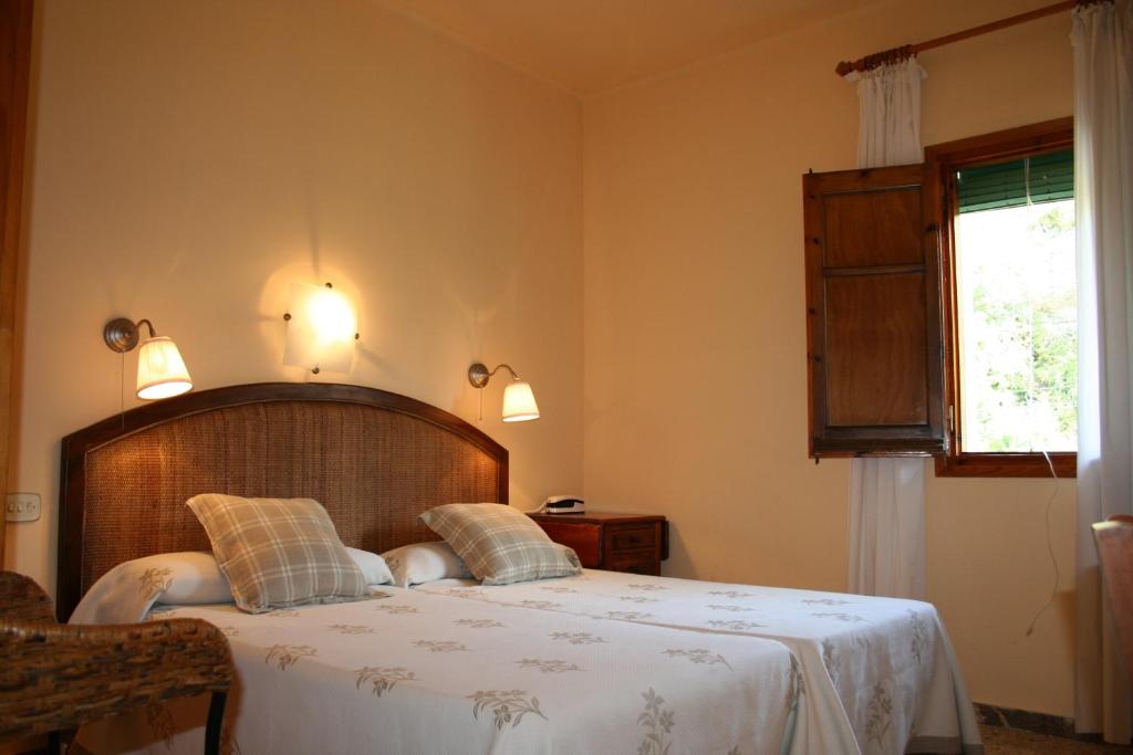 - une chambre avec un lit doté de draps blancs et une fenêtre dans l'établissement Hotel Casa Peix, à Serraduy