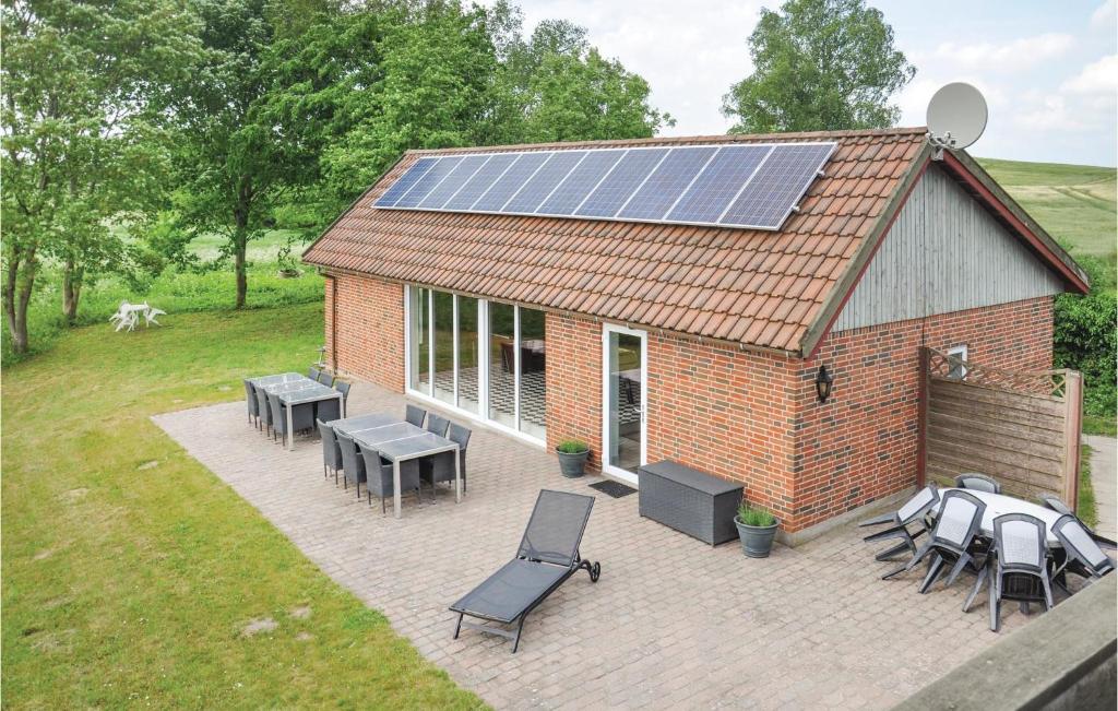 ein Haus mit einem Solardach mit Tischen und Stühlen in der Unterkunft Gorgeous Home In Faaborg With Sauna in Fåborg