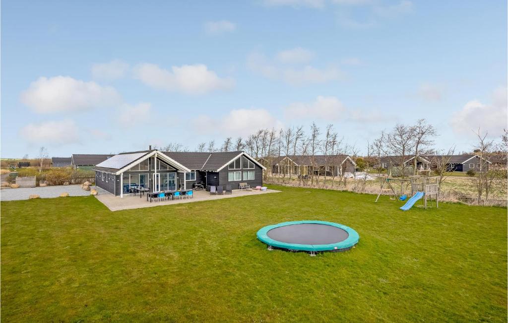 Bøtø ByにあるAmazing Home In Idestrup With 6 Bedrooms, Private Swimming Pool And Indoor Swimming Poolの家とトランポリンのある広い庭