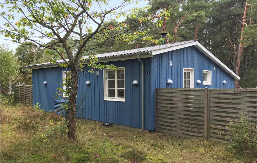 un cobertizo azul con una valla delante en Nice Home In Nex With Wifi en Balke