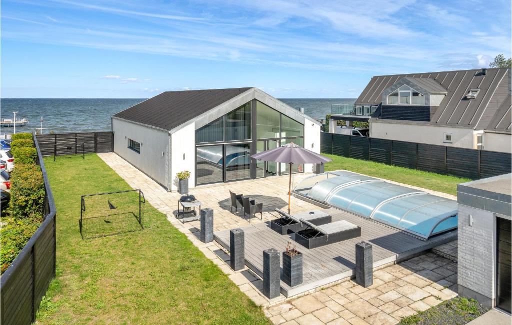 a house with a swimming pool next to the ocean at Amazing Home In Strby With House Sea View in Strøby