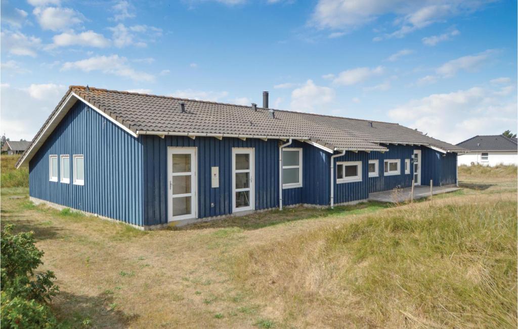 ブラーバンドにあるLovely Home In Blvand With Saunaの草原の青い建物