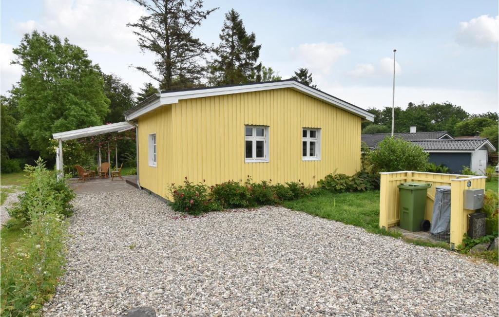 a yellow house with a gravel driveway at Nice Home In Frrup With Kitchen in Frørup