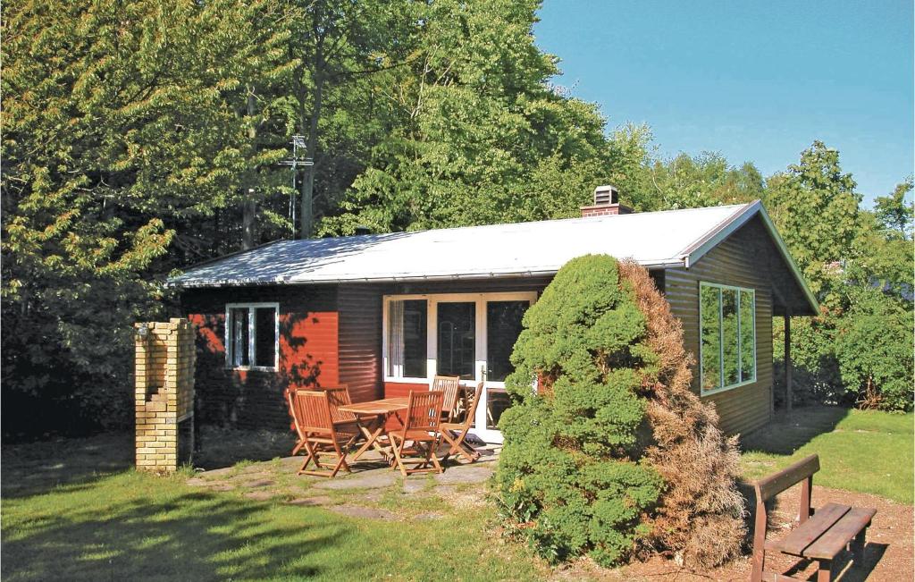 uma pequena cabana com uma mesa e cadeiras em frente em Pari em Rønne