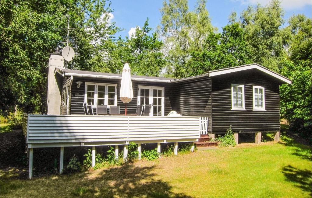 Vester Sømarken的住宿－3 Bedroom Pet Friendly Home In Aakirkeby，前面有长凳的小房子