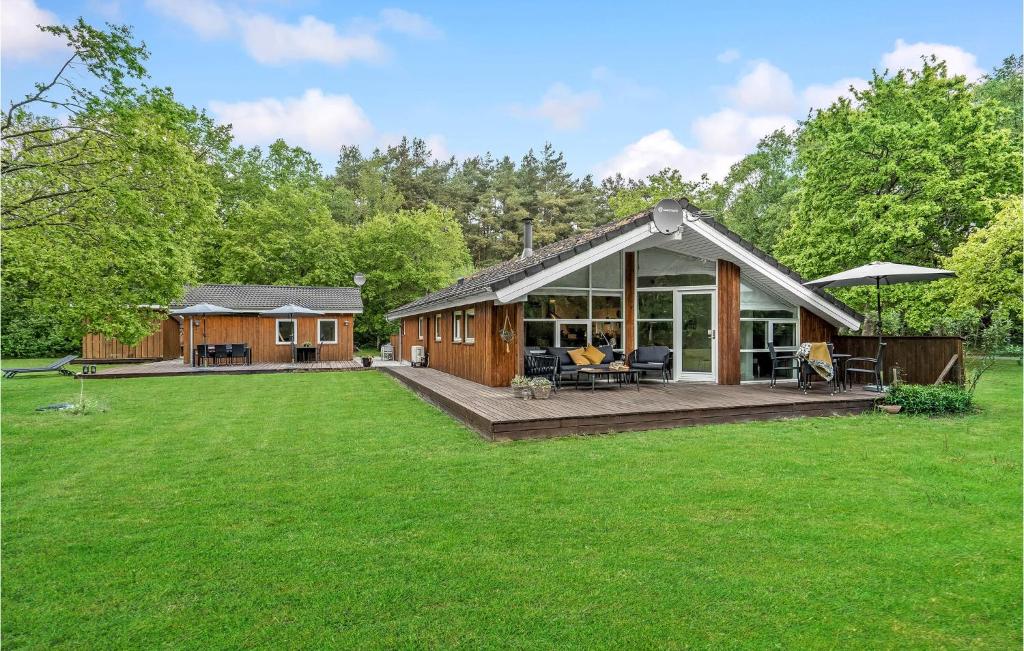 a house with a large yard with a deck at 4 Bedroom Cozy Home In Hadsund in Hadsund
