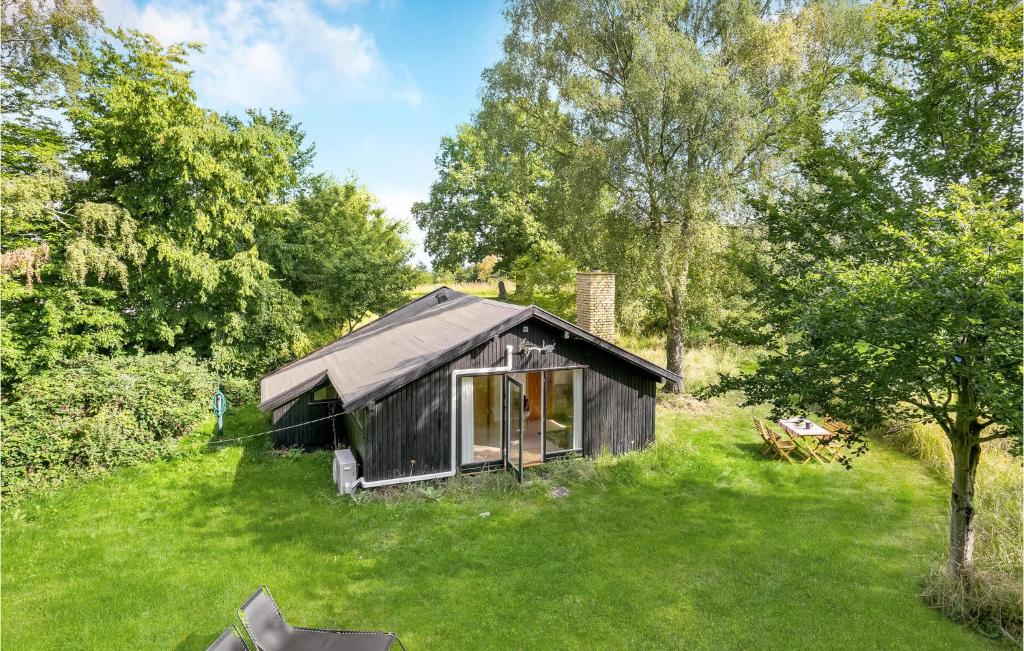 a small cabin in the middle of a grass field at 1 Bedroom Awesome Home In Jægerspris in Jægerspris