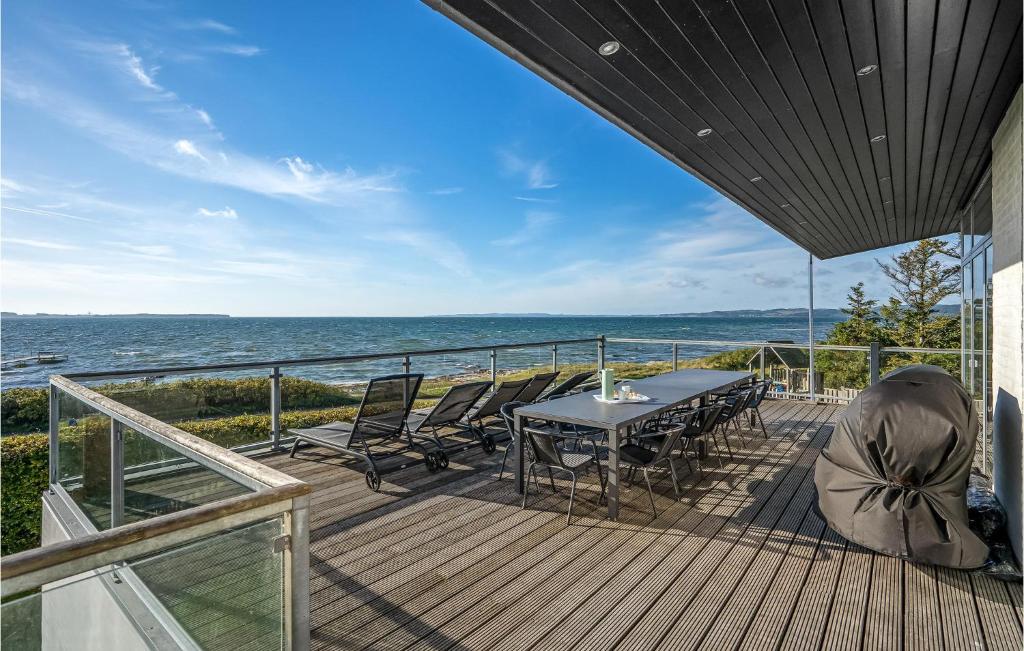 a deck with a table and chairs and the ocean at Pet Friendly Home In Ebeltoft With Kitchen in Ebeltoft