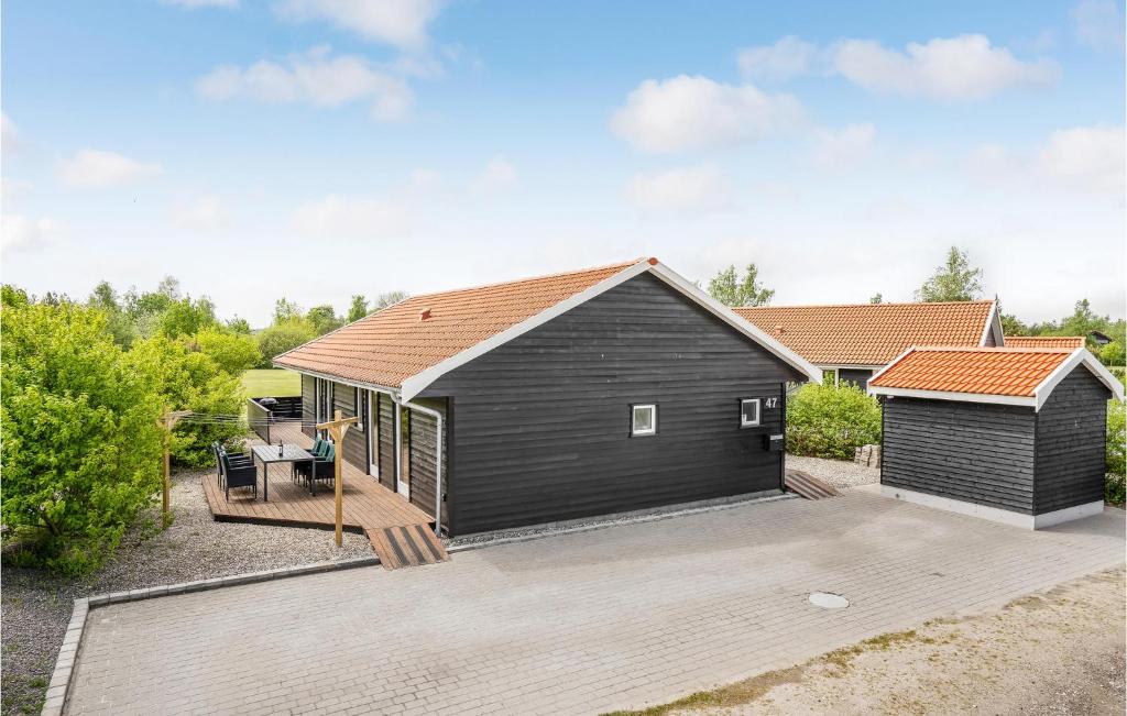 a black building with a deck and a house at Stunning Home In Vggerlse With 4 Bedrooms And Wifi in Bøtø By
