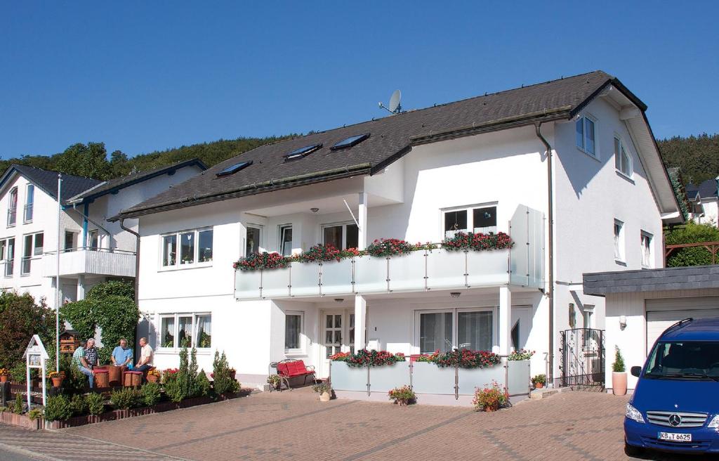 ein weißes Haus mit Menschen, die davor sitzen in der Unterkunft Haus Irmhild in Willingen