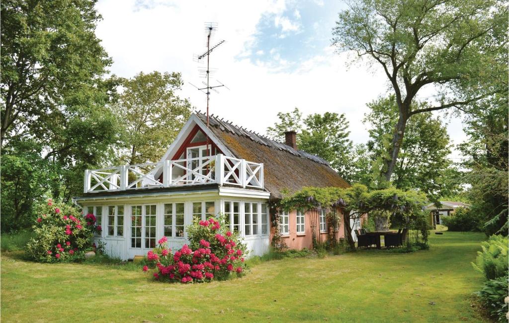 a house with pink flowers in the yard at Two-Bedroom Holiday Home In Gilleleje in Gilleleje