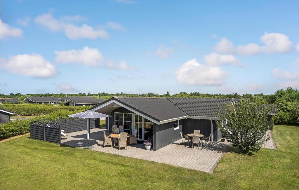 a gray house with a patio and a yard at 3 Bedroom Stunning Home In Hemmet in Hemmet