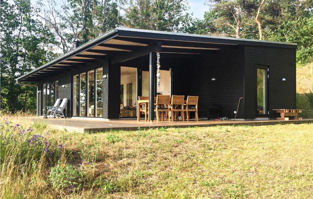 een zwarte cabine met stoelen en tafels in een veld bij Nice Home In Knebel With House Sea View in Knebel