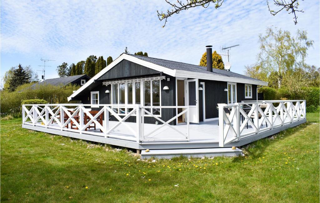 a small black and white house in a field at Gorgeous Home In Dronningmlle With Wifi in Dronningmølle