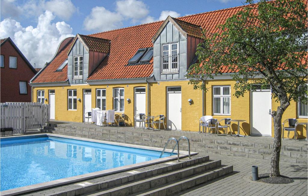 a house with a swimming pool in front of a house at Cozy Apartment In Gudhjem With Wifi in Gudhjem