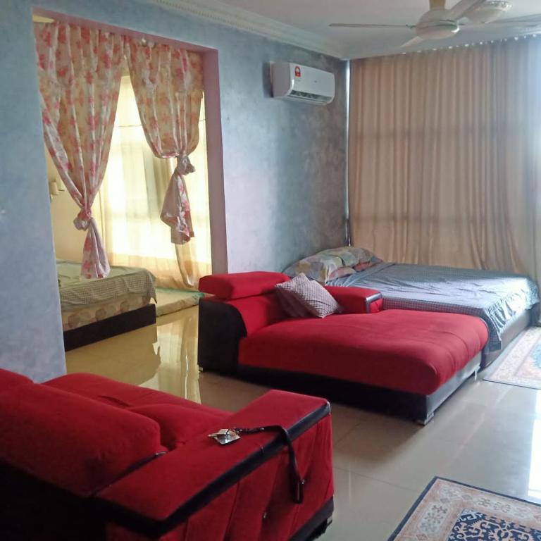 a living room with two beds and a couch at Nur vista in Kuala Selangor
