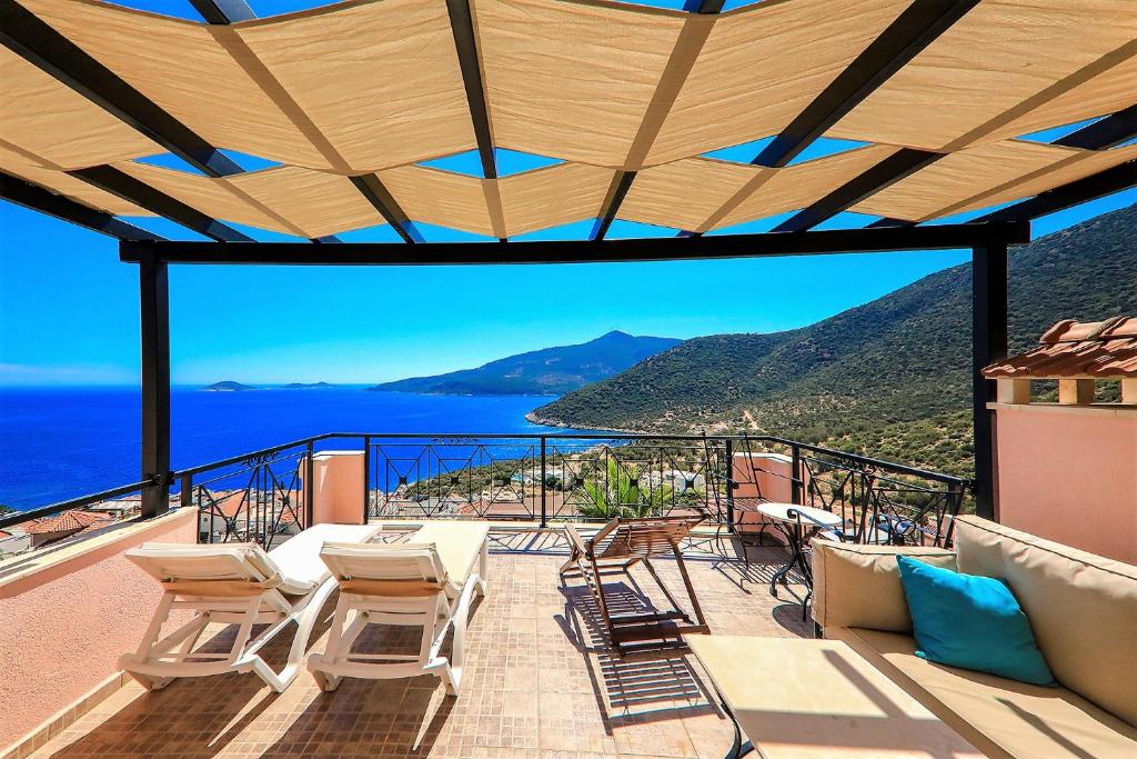 Un balcón con sillas y vistas al océano. en Villa Tymnessos en Kalkan