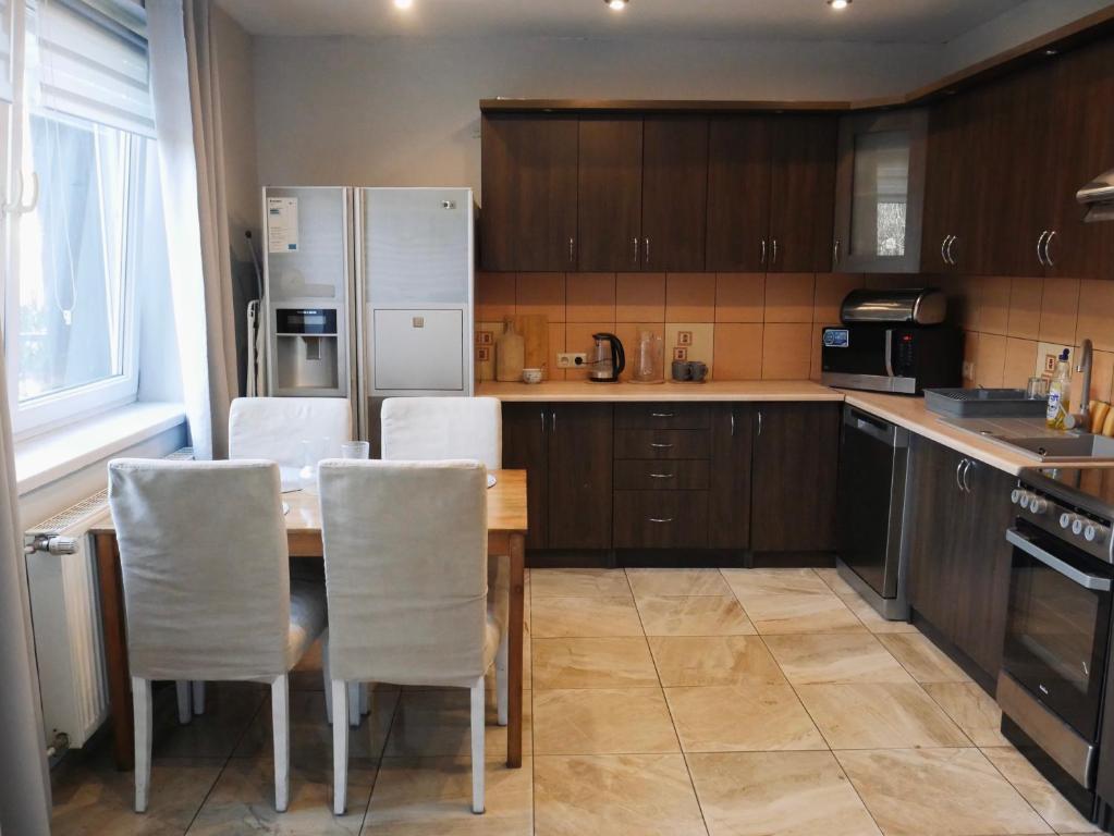 a kitchen with a table and chairs and a refrigerator at Apartamenty Pod Hutą in Węgierska Górka