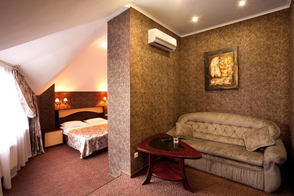 シンフェロポリにあるヴァレンシア ホテルのソファとベッド付きのホテルルーム