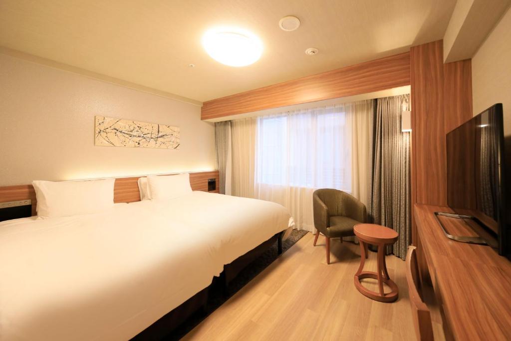 una camera d'albergo con letto e TV di Richmond Hotel Nagoya Shinkansen-guchi a Nagoya