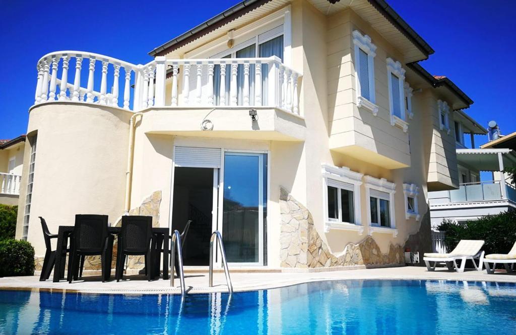 eine Villa mit einem Pool vor einem Haus in der Unterkunft Pleasant in Belek