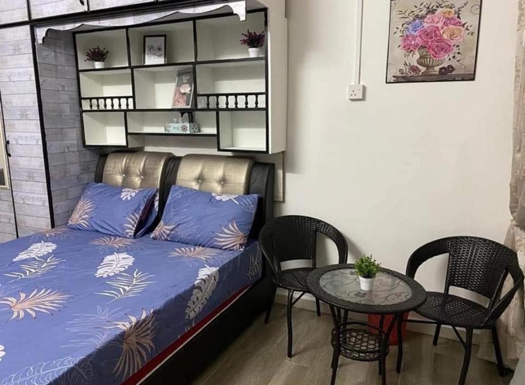 Zimmer mit einem Bett und einem Tisch mit Stühlen in der Unterkunft Homestay Kuala Kangsar Private Pool in Kuala Kangsar