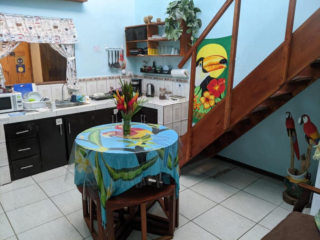 a kitchen with a table with a vase of flowers on it at Guesthouse Casa Lapa2 in Alajuela City