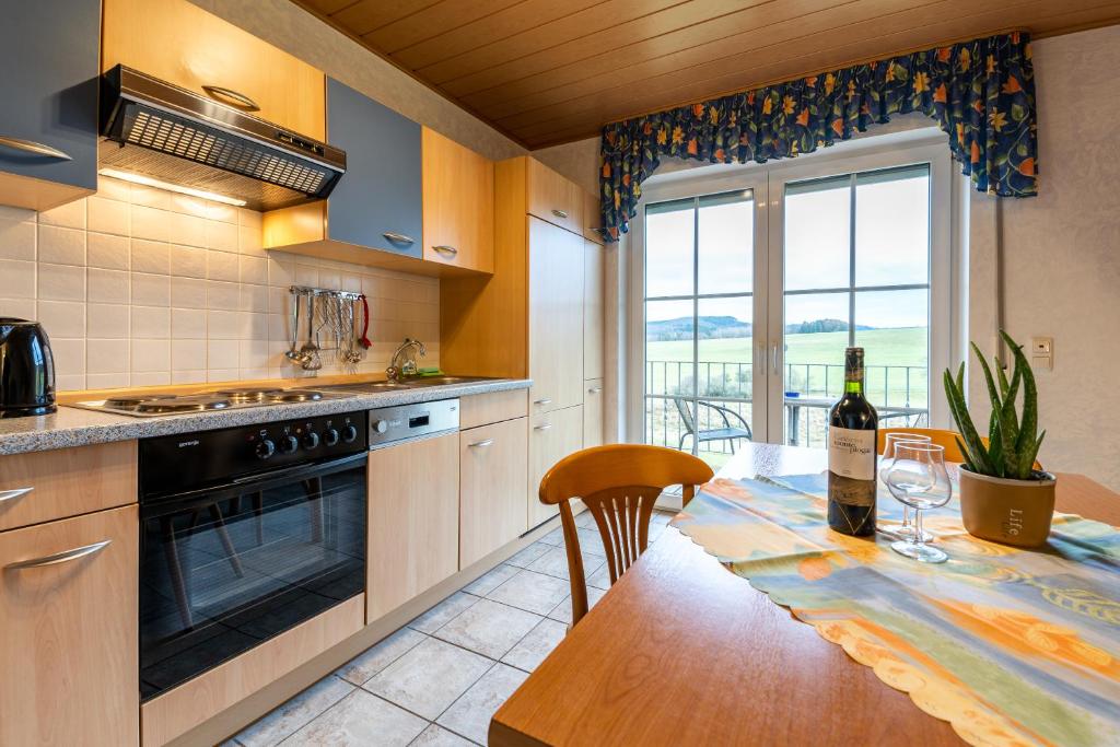 a kitchen with a table with a bottle of wine at Ferienwohnung Linda in Kelberg