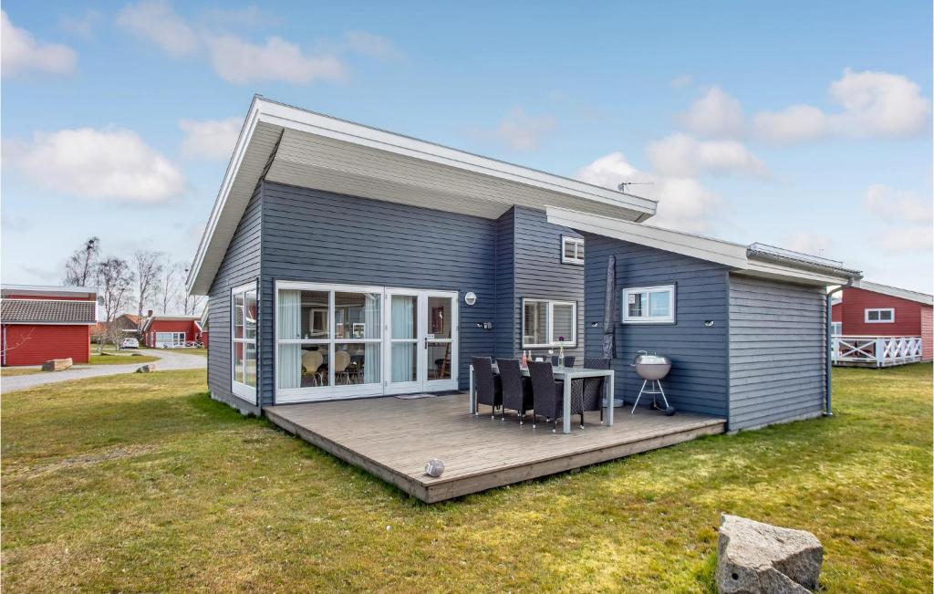 Casa azul con terraza y mesa en R Golfferiehuse, en Rø