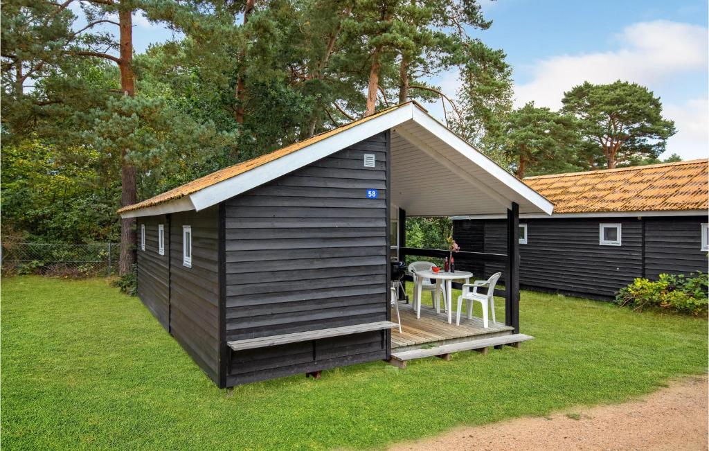 a small black shed with a table in the yard at 2 Bedroom Amazing Home In Nexø in Neksø