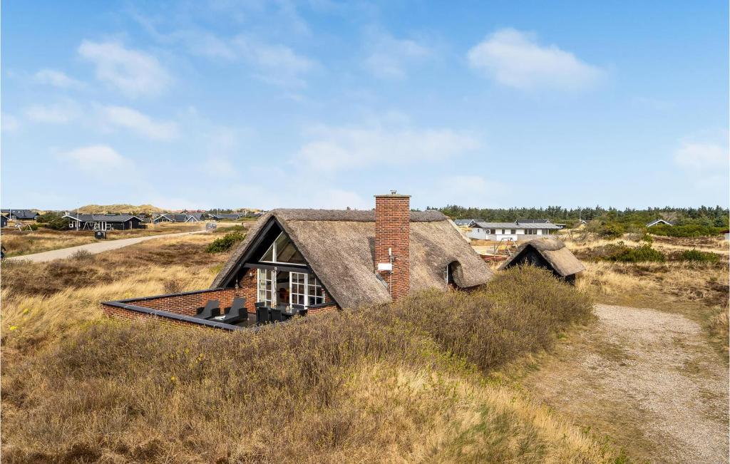 an old house in the middle of a field at Holiday Home Havklitvej Ringkøbing Vi in Ringkøbing