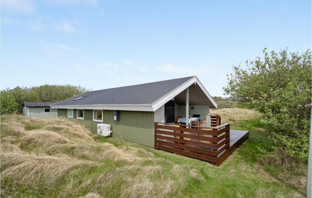 una casa verde con un ponte in un campo di Gorgeous Home In Fan With Wifi a Fanø
