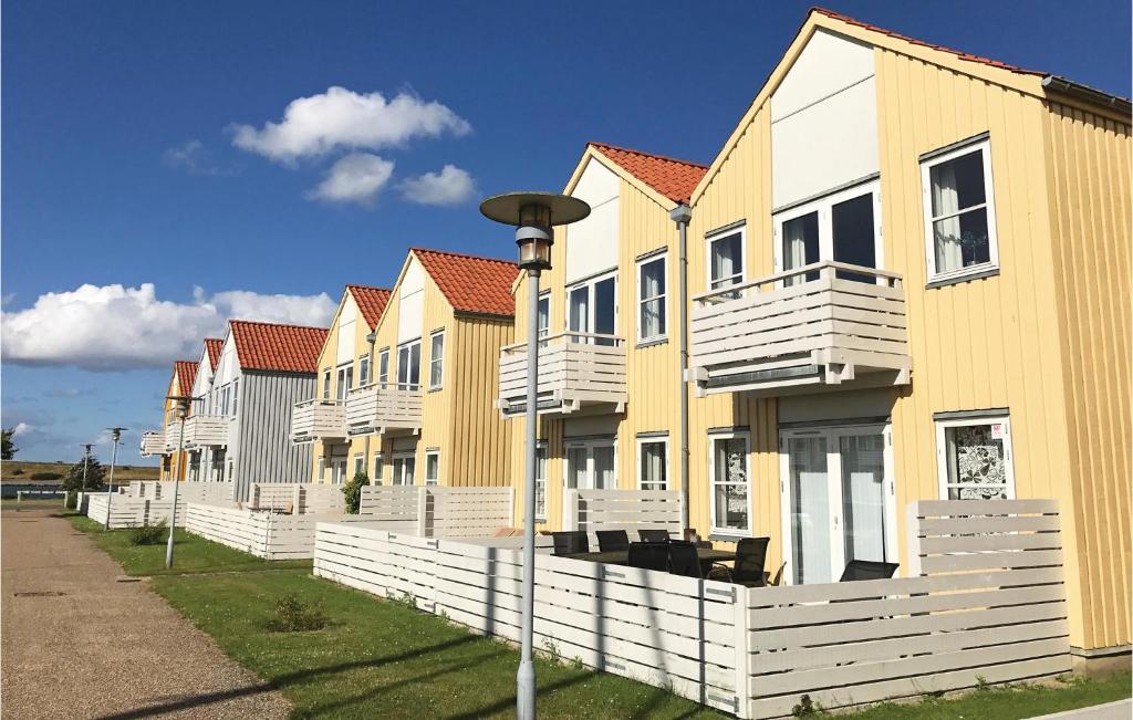 una fila de casas de color amarillo y blanco en Nice Apartment In Rudkbing With 2 Bedrooms And Wifi, en Rudkøbing