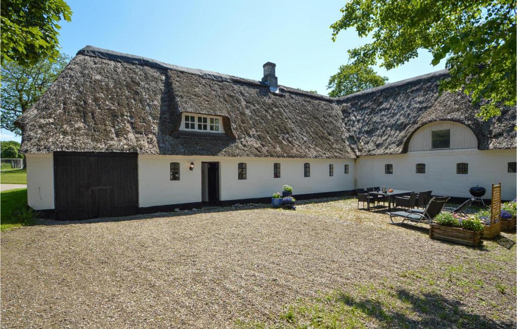 a large white barn with a thatched roof at Drosselgrden in Branderup