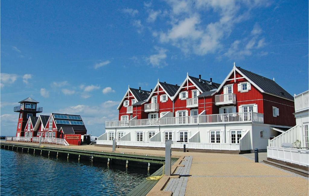 a large red and white building next to the water at Pet Friendly Apartment In Bagenkop With Harbor View in Bagenkop