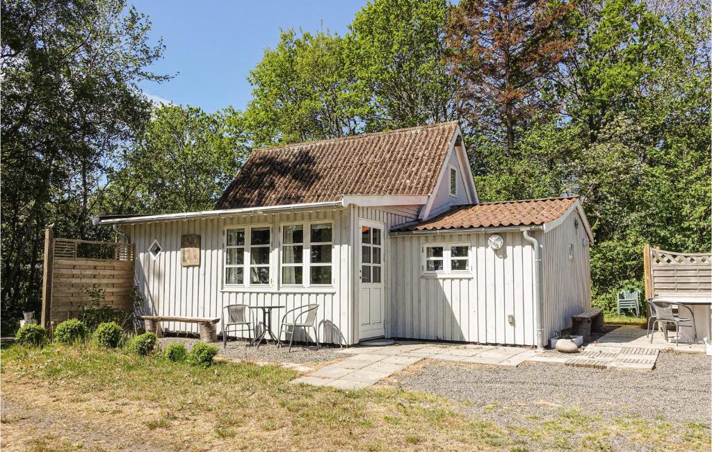 um pequeno barracão branco com uma mesa e cadeiras em Nice Home In Nex With Wifi em Neksø